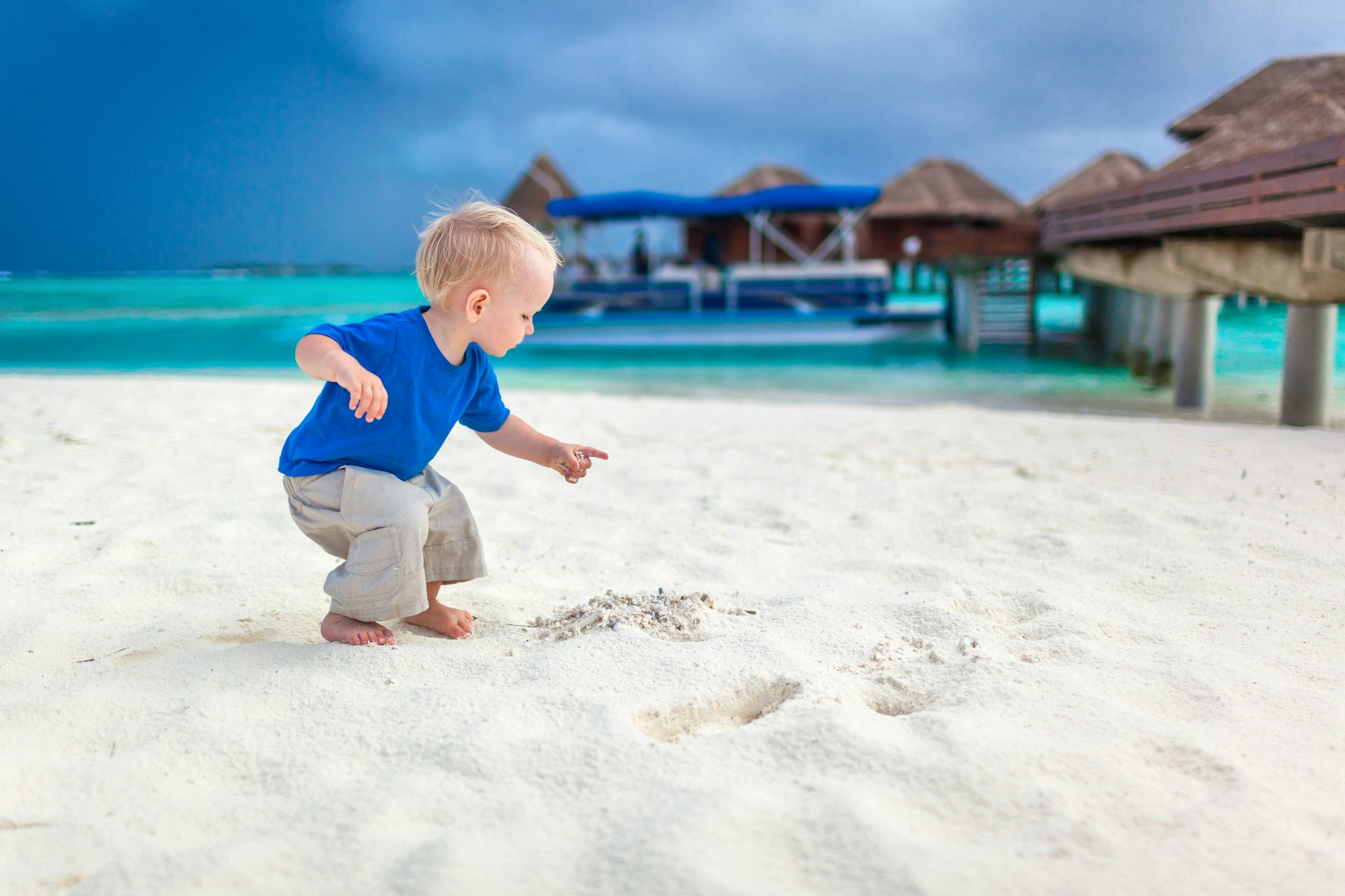 Cute little boy looking for treasure on the tropical beach